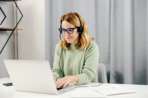 A sales representative on a sales team sits at her computer and uses new technology to boost her sales.